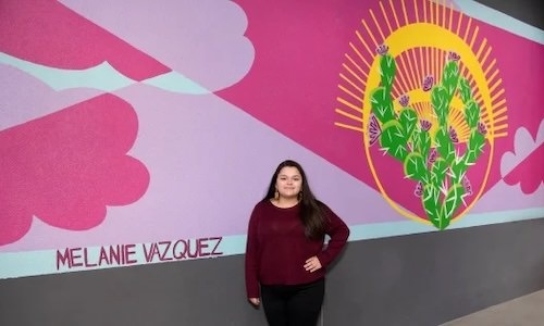 woman standing in front of mural