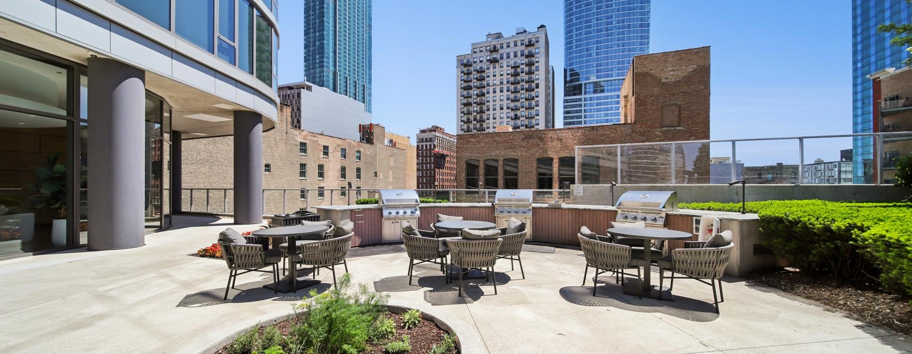 a courtyard with tables and chairs and buildings in the background